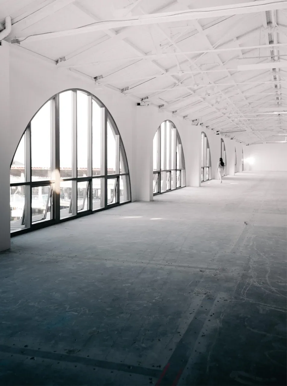 Industrihall med fogfritt golv och valvformade fönster.